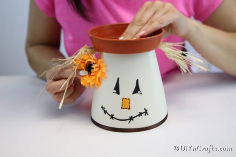 Decorative DIY Scarecrow Clay Pot Lantern - This DIY Scarecrow clay pot lantern is a great addition to your Halloween or Thanksgiving decoration plans. This lantern is perfect for displaying outside! Scarecrow Decorations, Diy Scarecrow, Scarecrow Crafts, Clay Pot People, Pot People, How To Make Lanterns, Fall Halloween Crafts, Fall Outdoor Decor, Clay Pot