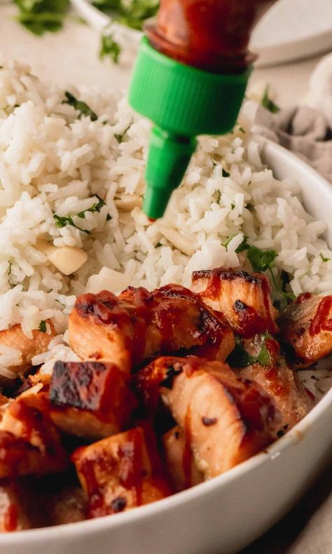 These delicious Honey Glazed Salmon Bites With Coconut Rice are the perfect combination of sweet and spicy. Featuring tender salmon coated in a sweet honey glaze with just a hint of crushed red pepper flakes for a touch of heat and served with coconut rice made with toasted coconut and fresh cilantro. And to top it off, this dish gets a drizzle of Sriracha to bring all those yummy flavors together perfectly! Glazed Salmon Bites, Honey Glazed Salmon, Salmon Bites, Honey Glazed, Glazed Salmon, Honey Glaze, Coconut Rice, Crushed Red Pepper, Crushed Red Pepper Flakes