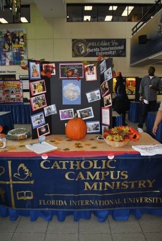 A display table promotes participation in Catholic Campus Ministry club at FIU's Biscayne Bay campus. Campus Ministry, Florida International University, Table Display, Display Board, College Life