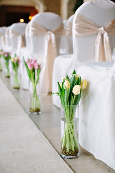 What a great idea to line the aisles! Here, simple arrangements of beautiful tulips add color and charm. Shop tulips year-round in a variety of stunning colors at GrowersBox.com! Wedding Flowers Tulips, Tulip Decor, Tulip Wedding, Ballroom Wedding, Aisle Decor, White Tulips, Deco Floral, Wedding Aisle, Wedding Table Centerpieces