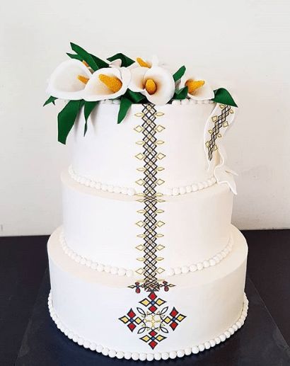 3-tier Habesha Wedding Cake Crowned with White Flowers | Clipkulture | Clipkulture Habesha Wedding Decoration, Habesha Kemis For Wedding And Eid With Traditional Patterns, Festive Fitted Habesha Kemis For Wedding, Traditional Fitted Habesha Kemis For Wedding, White Folk Habesha Kemis For Traditional Ceremonies, African Wedding Cakes, African Cake, Zulu Wedding, Festive Folk-style Habesha Kemis