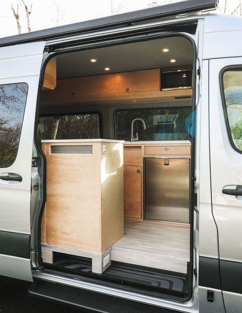 Sojourn - Freedom Vans Sprinter 144 Conversion, Corian Sink, Kitchen Galley, Laminate Plank Flooring, Converted Vans, King Sized Bed, Single Burner, Stainless Steel Microwave, Ottoman Cushion