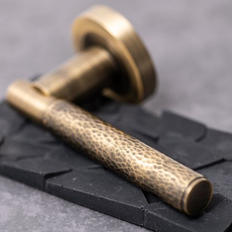 Introducing our Hammered Brass Lever on Rose Handle, a stylish blend of classic design and bespoke handcrafted style. Featuring a unscrewable round rose, this allows the fixings to be hidden behind the rose plate leaving a sleek aesthetic to your door. These sprung handles are sold as pairs and with all required fixings allowing for a quick and easy install upon delivery. The rich antique brass colour, featuring a hand-beaten finish, adds character to any door and compliments our other products Antique Brass Door Handle, Rustic Door Handles, Antique Brass Door Handles, Wooden Door Knobs, Bronze Door Knobs, Black Door Knobs, Porcelain Door Knobs, Internal Door Handles, Sliding Pocket Doors