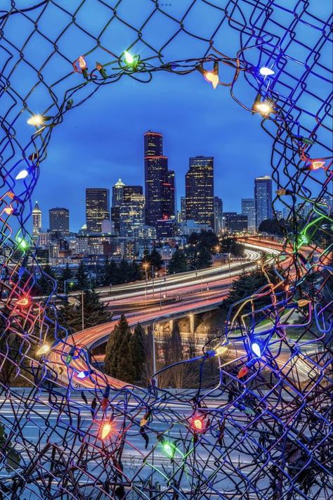 I grew up in Washington (State) | Downtown Seattle as seen through a decorated hole in the fence near Jose Rizal Park in Seattle | Facebook Seattle Christmas, Rizal Park, Jose Rizal, Visit Seattle, Evergreen State, The Greatest Gift, Downtown Seattle, Emerald City, The Fence