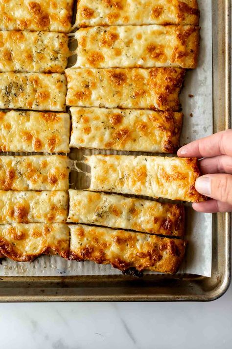 Made with just 5 ingredients, these cheesy breadsticks are an irresistible appetizer or side dish that's always the first to disappear! Start with pre-made or homemade pizza dough brushed with garlic herb butter, then load it up with mozzarella cheese. Bake until crispy and the cheese is extra melty. #cheesebreadsticks #breadsticks #cheesybreadsticks Breadsticks Easy, Oven Baked French Fries, Homemade Breadsticks, Cheesy Breadsticks, Bread Sticks Recipe, Creamy Chicken And Rice, Creamy Macaroni And Cheese, Creamy Mushroom Pasta, Cheese Bake