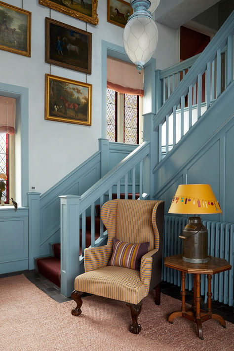 Blue wooden statement staircase with accent chair and mustard lamp shade. Hues of pale blue, gold and brown. Hallway Furniture Ideas, Blue Staircase, Hallway Panelling, Manor House Interior, Nicola Harding, Blue Hallway, Painted Staircases, House Staircase, Antique Furniture For Sale