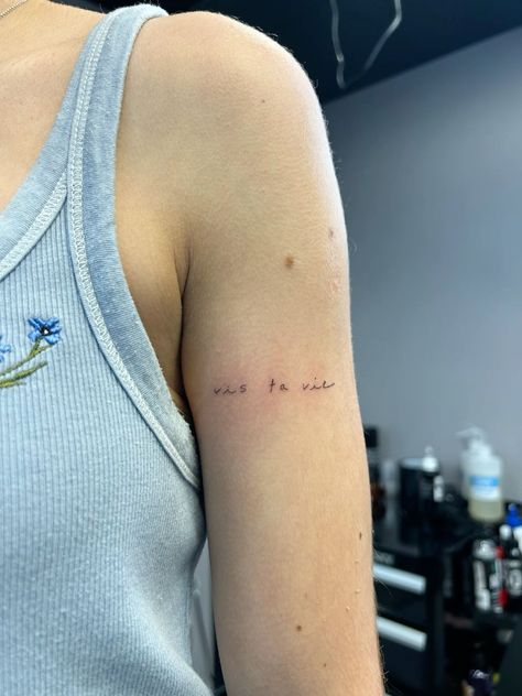 Secret French phrase cursive tattoo! ✨  Small & delicate, perfect for inner arm or bicep.  Hidden meaning, beautiful script. #cursive #tattoo #frenchtattoo #smalltattoo #innerarmtattoo #biceptatu #hiddenmeaning Writing On Bicep Tattoo, Small Writing Arm Tattoo, Tattoo Phrase Placement, Bicep Text Tattoo, Dainty Bicep Tattoo, Bicep Writing Tattoo, Upper Arm Word Tattoo, Arm Phrase Tattoo, Bicep Script Tattoo