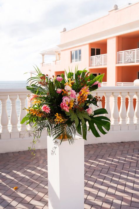 Tropical Rooftop Wedding Ceremony Decor, White Pedestal with Floral Arrangement, Monstera Palm Leaves, Pink Ginger, Yellow Flowers Monstera Floral Arrangements, Palm Beach Party, Tall Tropical Centerpieces Wedding, Tropical Flower Arrangements Wedding, Tall Tropical Centerpiece, Green White Tropical Wedding Flowers Tall Centerpieces, White And Green Tropical Centerpieces, Tropical Beach Wedding Arch, Rooftop Wedding Ceremony