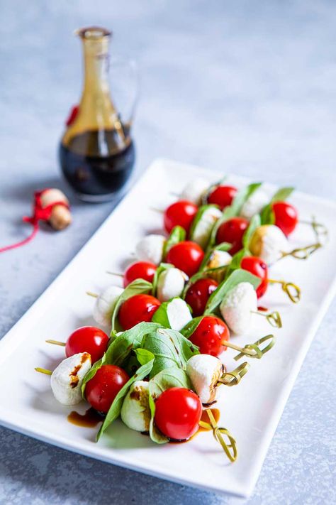 Caprese Skewers comprise cherry tomatoes, mozzarella pearls and basil leaves threaded onto cocktail sticks. Drizzle with balsamic vinegar. Click here! Vegetarian Starter Recipes, Salmon Terrine, Mozzarella Appetizers, Caprese Salad Skewers, Christmas Canapes, Vegetarian Starters, Mozzarella Pearls, Healthy Cheese, Caprese Recipes