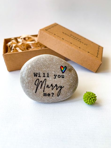 hand painted stone "Will you marry me" engagement ornament in craft paper box. This is unusual alternative wedding Lesbian engagement and gay promise ring. Lesbian Proposal Ideas Unique, Lesbian Proposal Ideas, Lesbian Proposal, Marry Me Engagement, Lgbtq Gifts, Lesbian Engagement, Unique Proposals, Engagement Ornament, Working Table