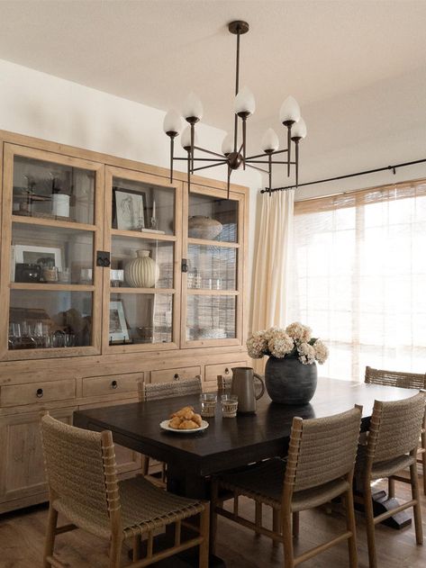 We love the look of mix and match dining room furniture. In her rustic modern dining room design, @accordingtomandy opted for an oversized dining room cabinet, dark wood dining table, and our woven rattan dining room chairs.