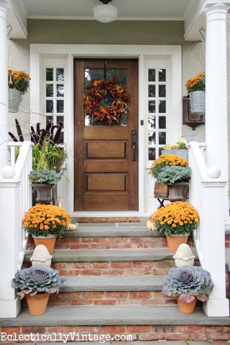 Having a warm welcoming porch is a simple way to start embracing the new season. Try adding plants with colors reminiscent of fall; some colorful “Garden Mums,” ornamental grasses or even purple kale are great for delivering a simple autumnal touch. Don’t forget about the planters, which will give the arrangement the complete look. Mansion Door, Front Door Steps, Front Porch Steps, Brick Steps, Wooden Front Doors, Porch Steps, Front Steps, Fall Front Porch, Fall Decorations Porch