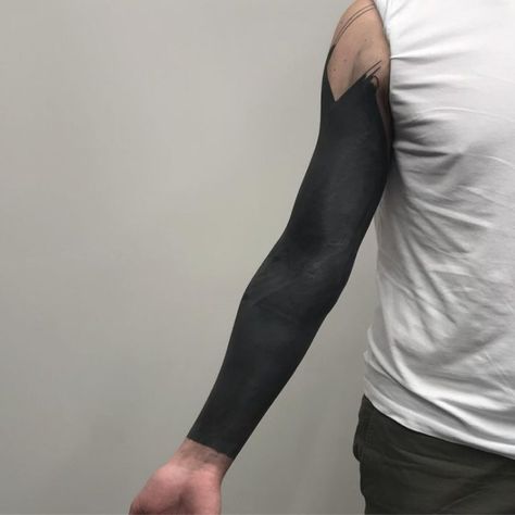 These Striking Solid Black Tattoos Will Make You Want To Go All In - KickAss Things All Black Sleeve Tattoo, All Black Arm Tattoo, Solid Black Tattoo Men, Blackout Tattoo Sleeve, Black Arm Tattoo, Arm Tattoos With Meaning, Black Arm Sleeve, Arm Tattoos Black, Black Sleeve Tattoo