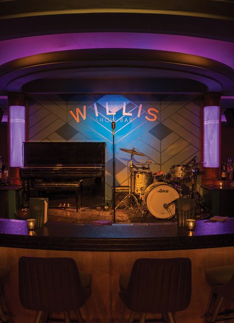 The signature curved bar at Willis Show Bar wraps around the front of the stage. Comedy Show Design, Cafe Music Stage, Restaurant Music Stage Design, Live Music Bar Stage Design, Band Stage Design, Stage Bar Design, Club Stage, Bar Stage Design, Music Bar Design