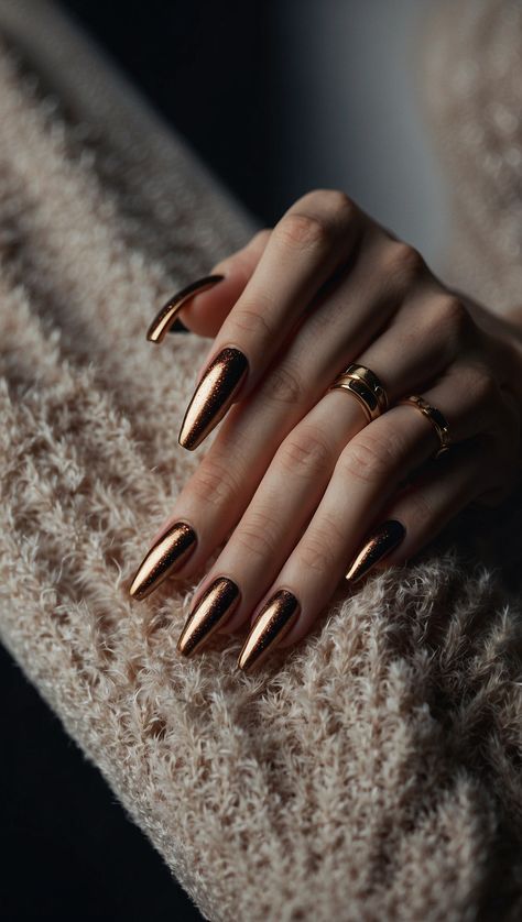 Close-up of a hand with long metallic bronze nails and rings on fingers Gold Bronze Nails, Cooper Chrome Nails, Romantic Nails Designs, Bronze Nails Designs, Copper Nails Designs, Hollywood Prom, Black Chrome Nails, Brass Nails, Metallic Nails Design