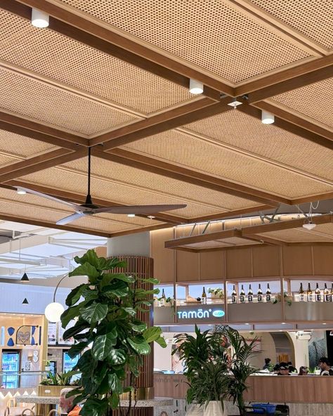 The House of Bamboo's ceiling screens, featuring engineered bamboo frames and rattan weave inserts, elegantly surround food kiosks at Sydney's Chatswood Chase Shopping Centre. Designed by MAKE Architects and constructed by Mettle, they highlight the durability and beauty of bamboo.  Click the link to view our portfolio.  #houseofbamboo #rattan #interiordesign #architecture Thatch Ceiling Interior, Rattan Design Interior, Wabi Sabi Ceiling Design, Tropical Ceiling Design, Bamboo Ceiling Design, Cafe Ceiling Design, Rattan Interior Design, Cane Ceiling, Cafe Ceiling