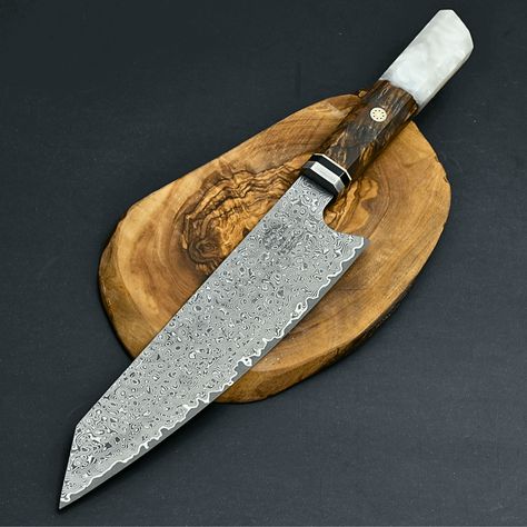 Aurora Damascus Steel Pro Chef Knife, 12.5" Overall, Damascus Steel Kiritsuke Blade with Exotic Olive Wood Burl & Resin Handle, Brass Mosaic Pins, Custom Full Tang Fixed Blade Kitchen Knife with Sheath, Knife Sharpening and Custom Personalization DAMASCUS BLADE DETAIL: The blade is expertly crafted by combining 1095 & VG10 Steel through layering, welding, and hammering, giving each blade a unique design akin to a fingerprint. Damascus steel is renowned for its strength and hardness. We enhance these properties by oil quenching it at 2100°F and cooling it rapidly, repeating the process twice to ensure its hardened to the core, achieving a hardness of 58 or higher on the Rockwell scale. SCALES & HANDLE DETAIL: The elegant handle is made from exotic olive wood burl and resin composite. It has Forge Ideas, Wood Burl, Damascus Kitchen Knives, Damascus Blade, Damascus Steel Knife, Damascus Knife, Steak Knives, Kitchen Knife, Knife Sharpening