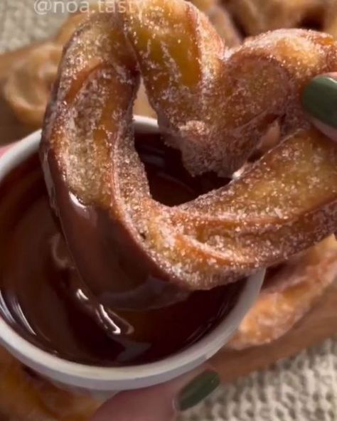 Sweettheavens on Instagram: "Heart-shaped churros 🎥 Credits @noa.tasty Follow @sweettheavens for more 🧁 Ingredients for 10 heart-shaped churros: 50g of butter Half a cup of lukewarm water (120ml) Half a teaspoon of vanilla extract 1 tablespoon of sugar A pinch of salt Half a cup of flour (70g) 2 eggs Sugar mixture: a quarter cup of sugar + a quarter teaspoon of cinnamon Chocolate sauce: 50g of dark chocolate + a quarter cup of heavy cream Instructions: 1. Prepare the Dough In a saucepan, combine the butter, lukewarm water, vanilla extract, sugar, and a pinch of salt. Bring the mixture to a boil over high heat, stirring continuously. After about a minute and a half, the mixture should start to bubble. At this point, reduce the heat to low and add the flour. Stir the mixt Sweet Dishes Recipes, Tasty Recipes Videos, Quick Recipes Snacks, Easy Baking Recipes Desserts, Tasty Baking, Bread Recipes Sweet, Healthy Sweets Recipes, Delicious Snacks Recipes, Fair Food Recipes