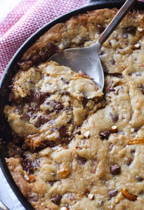 This Salted Caramel Pizookie is over the top delicious! A buttery chocolate chip cookie loaded with salted pretzels with a creamy caramel filling all baked in a skillet! Ooey gooey salted caramel deliciousness! #cookiesandcups #pizookie #castironskillet #skilletrecipe #skilletcookie #saltedcaramel Cookie In A Skillet, Pizookie Recipe, Buttery Chocolate Chip Cookies, Cast Iron Skillet Recipes Dinner, Skillet Cookie Recipe, Salted Caramel Cookies, Caramel Filling, Skillet Chocolate Chip Cookie, Caramel Chocolate Chip Cookies