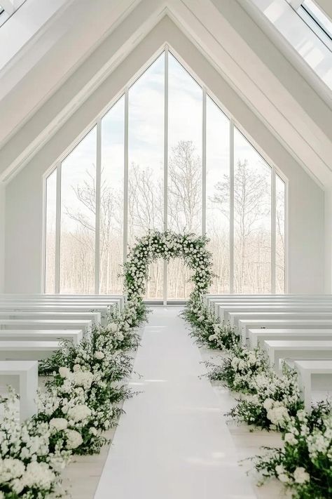 Bright and elegant wedding aisle with floral arrangements. Get enchanted by wedding decor ideas that remain elegant across the ages while impressing even the pickiest Aunt Mildred. Outside Wedding Aisle Runner, White Wedding Aisle Runner, Walking Aisle Wedding Decor, White Floral Aisle Arrangements, Floral Wedding Aisle Decorations, Flower Down The Aisle, Decorating Aisle For Wedding, White Flower Wedding Aisle, Wedding In Church Decorations