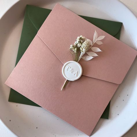 Samples will be posted in 1-2 working days. Personalised Wedding invitations with beautiful dusky pink pocketfolds, wax seals and dried flowers! The elegant design of the pockets is paired with Dark Green envelopes. Format: Pocket Fold Shape: Square Colour: dusky pink pocket and dark green envelope Items included: - dusky pink Pocket - Matte blush Backer - White Shimmer Insert Cards - White Initials Wax Seal - Dried Flowers - Dark Green Main Envelope - White RSVP - Blush RSVP Envelope Dimensions Wedding Invitations With Dried Flowers, Wedding Invitations Green And Pink, Dusky Pink Wedding Invitations, Wedding Invitations With Wax Seal And Dried Flowers, Blush And Dark Green Wedding, Wax Seal With Dried Flower, Pink And Dark Green Wedding, Green And Pink Wedding Invitations, Blush Pink And Sage Green Wedding