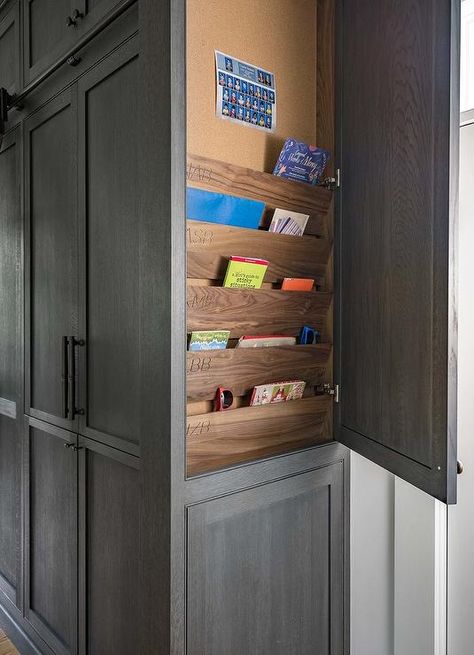 At the side of floor-to-ceiling dark gray oak cabinets accented with oil rubbed bronze pulls, an end panel swings open to reveal stained wood shelves fixed beneath a pin board. Kitchen Cabinets End Panels, Clean Kitchen Cabinets, Dark Grey Kitchen, Kitchen Transitional, Custom Kitchens Design, Wood Kitchen Cabinets, Grey Kitchen Cabinets, Family Kitchen, Transitional Kitchen