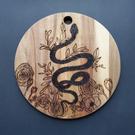 A functional and fully hand woodburned board with fun details. Check out my Instagram for more 🤎 #handmade Wood Burning Ideas Witch, Snake Wood Burning, Skull Wood Burning, Cottagecore Wood Burning, Pagan Wood Burning, Norse Wood Burning, Witches Woods, Snake Wood, Wood Burned Signs