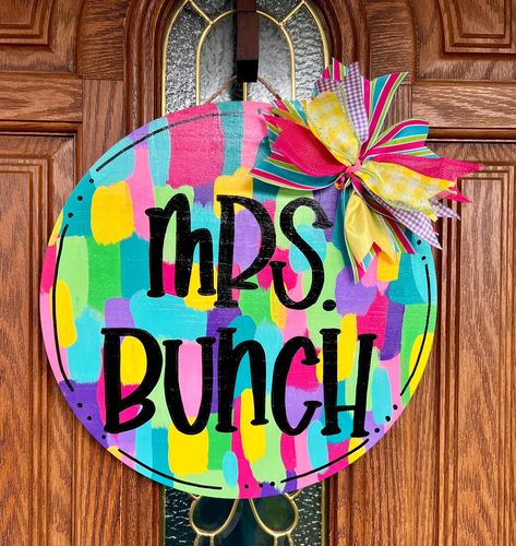 This product is a hand painted door hanger. The one pictured is 15 inches tall. We also offer an 18" version. This is the perfect accent to your classroom door and great for welcoming others! This Personalized Bright Paint Stroke Door Sign also makes a great gift for new teachers or your family members who are teachers.  Your sign will come to you fully sealed for outdoor use. Each item is hand-painted and hand-made, so slight variations can be expected. Made in Alabama!  ABOUT THIS DOOR HANGER: Painted Crafts To Sell, Round Teacher Door Hanger, Bright Door, Painted Banners, Art Room Doors, Teacher Door Hanger, Hand Painted Door, Bright Paint, Teacher Door Hangers