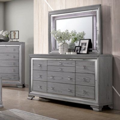 This beautifully finished light gray chest offers 8 regular drawers and 2 jewelry drawers that run on ball bearing metal glides with sturdy English dovetail construction. The mirror trim borders the drawers and complements the natural wood grain pattern perfectly. This piece rests on wooden brack feet for extra stability and balance. | Everly Quinn Orrwell 10 Drawer Double Dresser w / Mirror Wood in Brown / Gray, Size 41.0 H x 66.0 W x 17.5 D in | Wayfair Light Gray Bedroom, Transitional Dresser, Drawers Design, Grey Dresser, Mirror Trim, Oak Dresser, Wood Grain Pattern, 9 Drawer Dresser, Gray Mirror