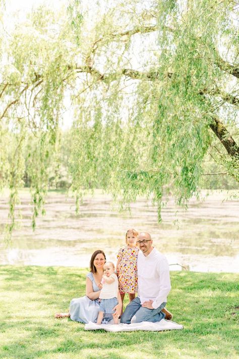 Beautiful family of 4 sitting under a willow tree smiling during a Spring family session in New Paltz, NY. Mom is in a blue dress, oldest daughter is in a yellow floral dress, baby is in a cream shirt with light blue shorts, dad is wearing a button up white shirt with jeans. Willow Tree Family Photos, Weeping Willow Tree Photography, Family Photos Under Willow Tree, Willow Tree Family, Willow Tree By Pond, Willow Tree Maternity Photos, Engagement Photos Willow Tree, Irwin Family, New Paltz