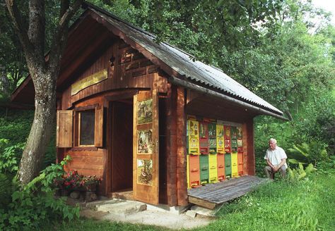 A European (Slovenian) bee shed with decorated hives. Notice the folding door in front of the hives.  I'm guessing it closes during the winter. Bee Shed, Bee Hive Plans, Bee Houses, Raising Bees, Bee Supplies, Buzzy Bee, Bee House, Bee Boxes, Bee Farm