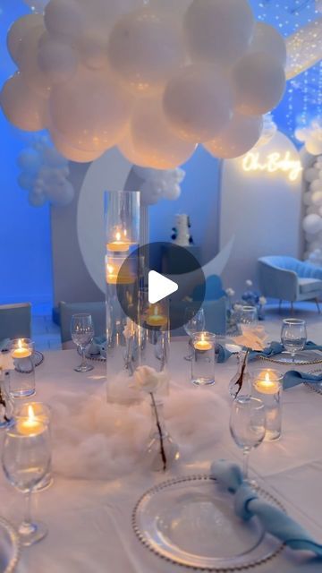 Margaret| Venue + Event Planner on Instagram: "✨ Oh Baby! Last night’s baby shower was a dream in shades of soft blue and white, creating a heavenly cloud-like atmosphere! ✨

From the delicate draped fairy lights overhead to the cascading white balloons, every detail added a touch of whimsy and wonder to celebrate this little one’s arrival. Guests were seated at tables adorned with floating candles, sleek glass vases, and chic blue napkins, enhancing the serene ambiance. Each table had stunning white florals, blending perfectly with the cozy blue and white color palette.

The highlight of the setup? A beautiful backdrop featuring a crescent moon and fluffy cloud decor, with an “Oh Baby” neon sign glowing softly above, adding the perfect finishing touch. This setup was all about capturing t Cloud Balloons Decorations, Heavenly Sent Baby Shower Theme, Blue And White Balloon Decorations, We're On Cloud 9 Baby Shower Theme, Moon And Stars Centerpiece Ideas, Cloud Nine Centerpiece, Cloud Theme Baby Shower Centerpieces, Cloud Gender Reveal Centerpieces, Cloud Nine Baby Shower Cake