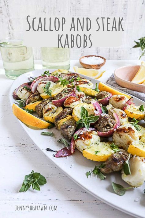 A recipe for grilled scallop and steak kabobs with veggies. The kabobs are on a white plate with fresh herbs on top. Surf And Turf Kabobs, Veggies Grilled, Steak And Veggies, Steak Kabobs, Beef Kabobs, Sirloin Tips, Beach Dinner, Surf And Turf, Pepper Steak