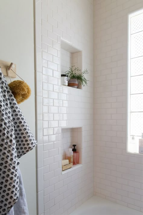 Love the way these little niches have been added to the design in this bathroom. They're perfect for storing bathroom essentials, like shower gel or soap, or for adding a plant or two. Small Full Bathroom With Tub, Airbnb Photography, White Subway Tile Bathroom, Makeover Kamar Mandi, Metro White, Spare Bathroom, Subway Tiles Bathroom, Hallway Bathroom, Bad Inspiration