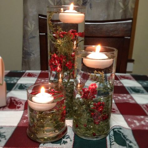 Holiday centerpiece with floating candles. I found the smaller two glasses, the fake berries, and the stones at the dollar store. The tall glass and the floating candles were bought at Michaels. The berries float so I cut them long and put them in first then the stones to hold them in place. Frost Christmas Decor, Christmas Candle Centerpieces, Floating Candle Decorations, Centerpieces Candles, Centerpieces Christmas, Candle Decorations, Floating Candle Centerpieces, Candle Table Decorations, Christmas Candle Decorations