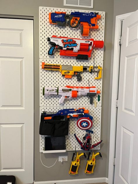 Nerf gun storage solution: from a toy pile to a cool display system – Homely House Toy Room Storage Wall, Big Toy Organization, Nerf Storage Ideas Peg Board, Nerfgun Storage, Pegboard Nerf Wall, Nerf Wall Storage, Playroom Wall Storage, Nerf Organization Ideas, Peg Board Nerf Wall