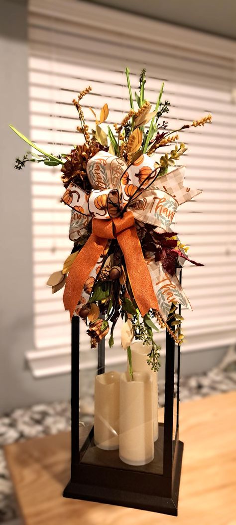 Add seasonal charm with a stunning Lantern Swag! Multiple fall options to choose from and each piece features a blend of rich, seasonal elements. Floral picks and leaves with luxurious flowers adds a touch of elegance. Each swag bring a natural, woodland feel, making either swag perfect for cozy fall decor. Layers of  wired ribbons with shades of orange, brown, yellow, green, and hint of blue add depth and texture. Ribbon colors will vary per piece design. Whether you're looking to adorn a lante Fall Decorated Lanterns Ideas, Fall Candlestick Arrangements, Fall Birdcage Decor Ideas, Fall Chandelier Decorations, Fall Lantern Ideas, Fall Floral Arrangements For Home, Lantern Decor Living Room, Open Lantern Decor Ideas, Lantern Fall Decor