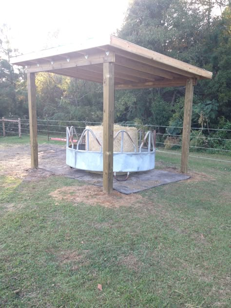 Perfect round bale holder for my front pasture. Thanks to my perfect husband. 12x12 roof, 8' hay ring. Feed Shed Ideas, Horse Pasture Shelter, Hay Storage Ideas, Horse Pasture Ideas, Round Bale Shelter, Hay Shelter, Diy Round Bale Hay Feeder For Horses, Hay Hut, Hay Ring