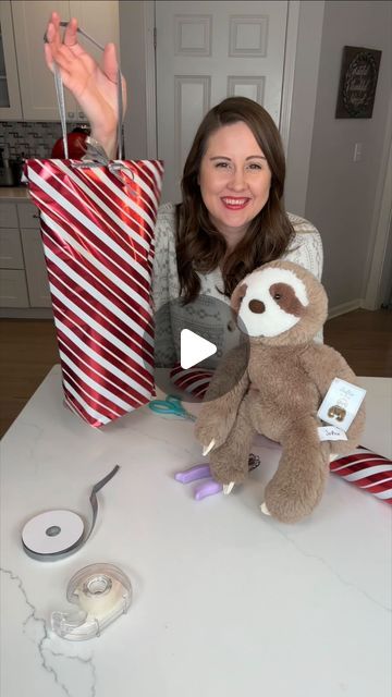 YWM Family on Instagram: "✨ Struggling to wrap plush toys or odd-shaped gifts? 🎁Here’s a holiday hack you’ll love, SAVE this! 💕 With some wrapping paper and a little ribbon, you can create the cutest package—complete with a handle to carry! Perfect for adding a special touch to your holiday gifting. 🎄🎀

Comment SHOP below to receive a DM with the link to shop this post on my LTK ⬇ https://liketk.it/4XcNS #ltkholiday #ltkfamily #ltkseasonal

#GiftWrappingHack #HolidayTips #FestiveGifts #WrappingPresents #HolidayGiftWrap" Gift Wrapping Ideas Clear Bags, How To Wrap A Doll Present, How To Wrap Plush Toys, Odd Shaped Gift Wrapping Ideas, Silly Gift Wrapping Ideas, How To Wrap A Stuffed Animal Present, Wrapping A Stuffed Animal, Wrapping Tube Shaped Gifts, Gift Wrapping Stuffed Animals