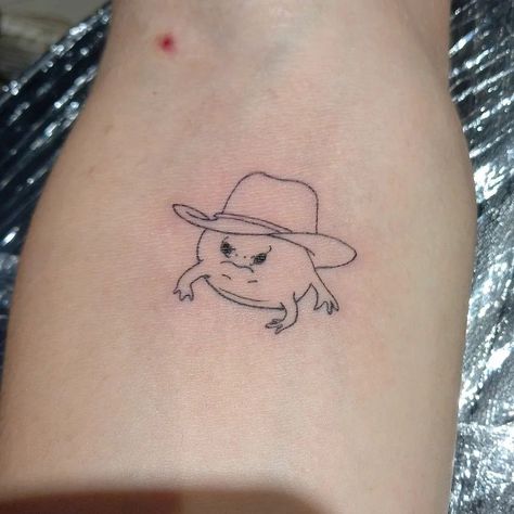 Frog In Hat Tattoo, Yakult Tattoo, Frog Tattoo Simple, Cowboy Frog Tattoo, Funny Tattoo Designs, Silly Little Tattoos, Silly Tattoo Ideas, Frog Tattoo Ideas, Silly Tattoos