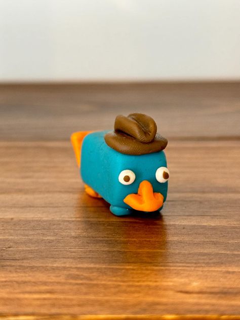 🦆 Meet Perry the Platypus, your favorite secret agent in an adorable handmade polymer clay figurine! Ready to join your collection! Clay Easy Projects, Small Modeling Clay Ideas, Small Clay Designs, Clay Inspiration Easy, Clay Perry The Platypus, Polymer Clay Ideas Animals, Cute Clay Things Easy, Air Dry Clay Date Ideas, Clay Little Figures