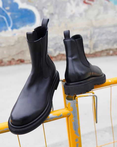 A pair of black leather Officine Creative Chelsea boots with chunky lug sole on top of a fence. This image was included in the article: 25 Luxury Shoemakers Crafting The Finest Men’s Boots, on MensFlair.com Luxury Masculine Chelsea Boots With Leather Sole, Luxury Classic Men's Chelsea Boots, Luxury Masculine Goodyear Welted Chelsea Boots, Luxury High-top Men's Chelsea Boots, Luxury Masculine Chelsea Ankle Boots, Leather Hiking Boots, Luxury Boots, Brogue Boots, Officine Creative