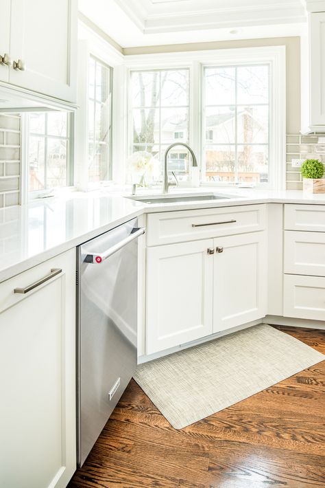 Strategically using the corners, our designer placed the sink in the corner to maximize space, while also including a gorgeous, sprawling window to look out of while doing the dishes Sink Corner Kitchen, Sink In Corner Of Kitchen, U Shaped Kitchen With Corner Sink, Corner Window Kitchen Ideas, Corner Upper Kitchen Cabinet By Window, Corner Kitchen Window Ideas, Corner Window Kitchen Layout, Corner Windows Kitchen, Kitchen Corner Windows Over Sink