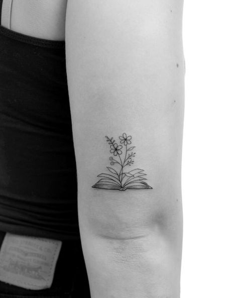 20 Beautiful Book Tattoos That Tell Your Story Book Tattoo Back Of Arm, Tiny Book Tattoo Minimalist, Little Women Tattoo Ideas, Literature Tattoos Minimalist, Small Bookish Tattoos, Bookworm Tattoo Ideas, Floral Book Tattoo, Minimalist Book Tattoo, Simple Book Tattoo