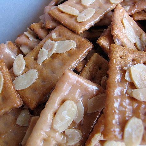 Almond Crackers  Sprinkle sliced almonds over. Mix butter (2 sticks) and sugar (2/3c) in saucepan. Cook just until it comes to a boil and stirring constantly. Quickly spread butter mixture over all crackers. Bake at 350 degrees for 10 minutes. Quickly remove from pan and place on foil to cool. Almond Crackers Recipe, Almond Crackers, Graham Cracker Butter, Almond Snack, Club Crackers, Cracker Candy, Butter Crackers, Cracker Toffee, Crackers Recipe