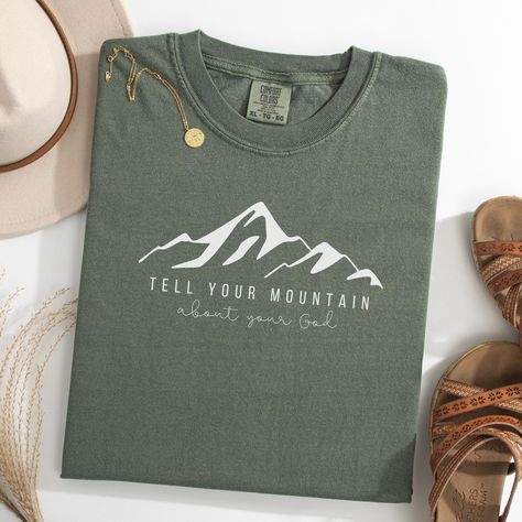 Your Mountain Comfort Colors T-Shirt. Christian Tops for Women. Bible Verse Crewneck. Faith Tee. Simple Church TShirt. Trendy Catholic Gift. Show your faith with this "Tell Your Mountain About your God" t-shirt, inspired by Mark 11:22-24. This trendy Christian tee features the empowering message from Mark's gospel with a beautiful mountain range, making it a perfect reminder of your faith and a stylish addition to your wardrobe. Made with soft, high-quality fabric for ultimate comfort, it's idea God Tshirts Design, Christian Shirt Design Ideas, Aesthetic Christian Shirts, Simple Christian Tshirts, Mountain Shirt Design, Christian Tshirts Designs Woman, Simple Bible Shirts, Christian T Shirt Ideas, Christian Shirt Designs