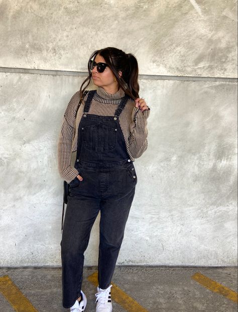 Brunette in high pony with quay sunglasses, brown cropped turtleneck sweater, black old navy overalls, and white adidas superstar sneakers Maternity Black Overalls Outfit, Overalls And Sweatshirt, Jacket Over Overalls, Black Overalls Sweater Outfit, Corduroy Overalls Outfit Winter, Flannel Overalls Outfit, Christmas Overalls Outfit, Black Overalls Outfit Winter, How To Style Overalls