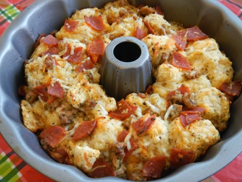 Easy Pull Apart Pizza Bread *2 (14 oz.) cans of Pillsbury pizza dough (you can use Grand biscuits) *2 cups shredded Mozzarella cheese *1/2 tbsp. basil leaves *1/2 tsp. dried oregano *1/2 tsp. fresh minced garlic *1/3 cup olive oil *1 (8 oz.) package of pepperoni (cut into quarters) *1 cup Parmesan cheese Pull Apart Cheese Bread, Pillsbury Pizza, Pizza Monkey Bread, Pull Apart Pizza Bread, Pull Apart Pizza, Pizza Bread Recipe, Bundt Pan Recipes, Bread Packaging, Canned Biscuits