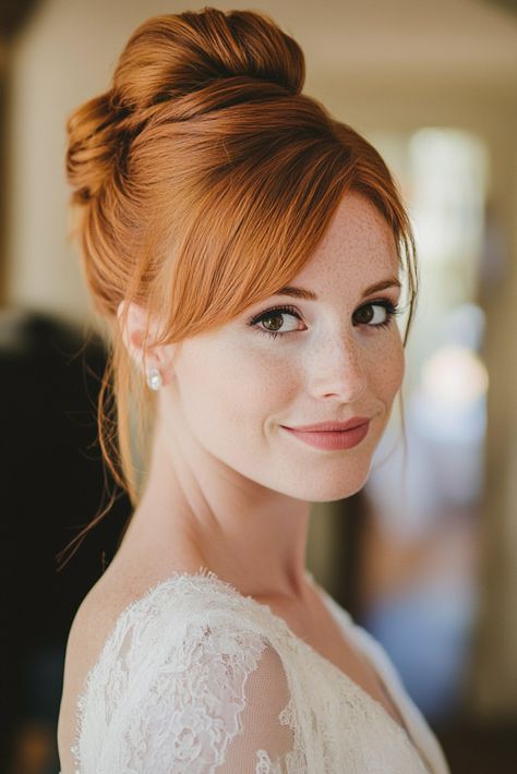 A woman with red hair styled in an updo smiles softly. She is wearing a lace wedding dress and small pearl earrings, with soft, natural lighting highlighting her features. High Bun Bridal Hair, High Bun Bridal, Bun Bridal Hairstyles, Red Hair Wedding, Red Hair Updo, Bun Bridal Hair, Redhead Bride, Wedding Hairdos, High Buns