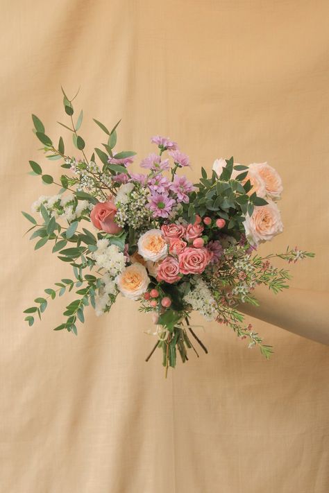 Our small hand-tied bouquet features a variety of our freshest seasonal blooms, finished with greenery. All hand-tied bouquets are wrapped in our signature paper wrapping and finished with raffia or ribbon. Choose between: Designer's choice >> Leave it to us to design a beautiful bouquet for you. Soft >> Soft, muted shades such as white, cream, blush, pale pink, and lavender. Bold >> Rich, vibrant shades such as yellow, purple, orange, red and pink. Pop of colour >> A mix of soft and bold: a viv Pink Flower Arrangements, Peach Bouquet, Red Bouquet Wedding, Hand Tied Bouquet, Prom Flowers, Paper Wrapping, Hand Bouquet, Bouquet Wrap, Colorful Bouquet